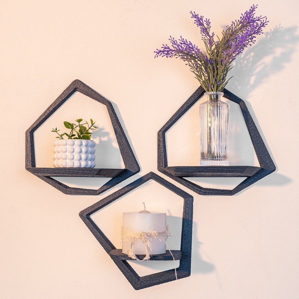 Kit 3 nichos geométricos de parede impressos em 3D cor preta, decorados com pequeno vaso de planta, vela e flores de lavanda em parede clara.